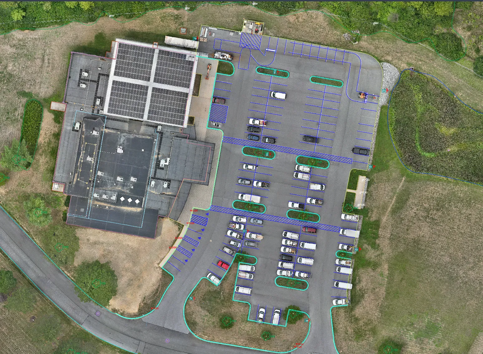 Aerial photograph with CAD overlay showing building, parking lot, and site plan annotations