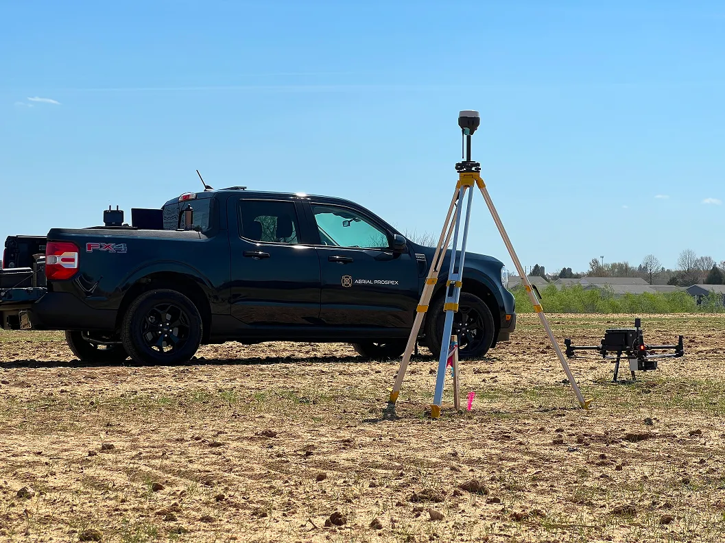 Aerial Prospex surveying setup with truck, GPS receiver, and drone